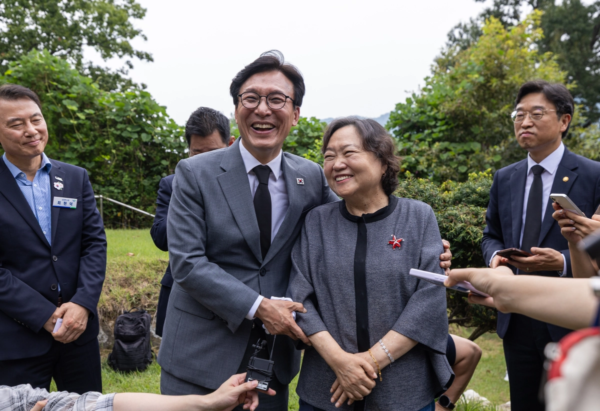 김민석(왼쪽) 더불어민주당 대표가 20일 경기 남양주시 모란공원에 위치한 김근태 전 민주당 상임고문 묘역을 참배한 뒤 김 전 고문의 배우자인 인재근 전 의원과 인사를 나누며 환하게 웃고 있다. 더불어민주당 제공
