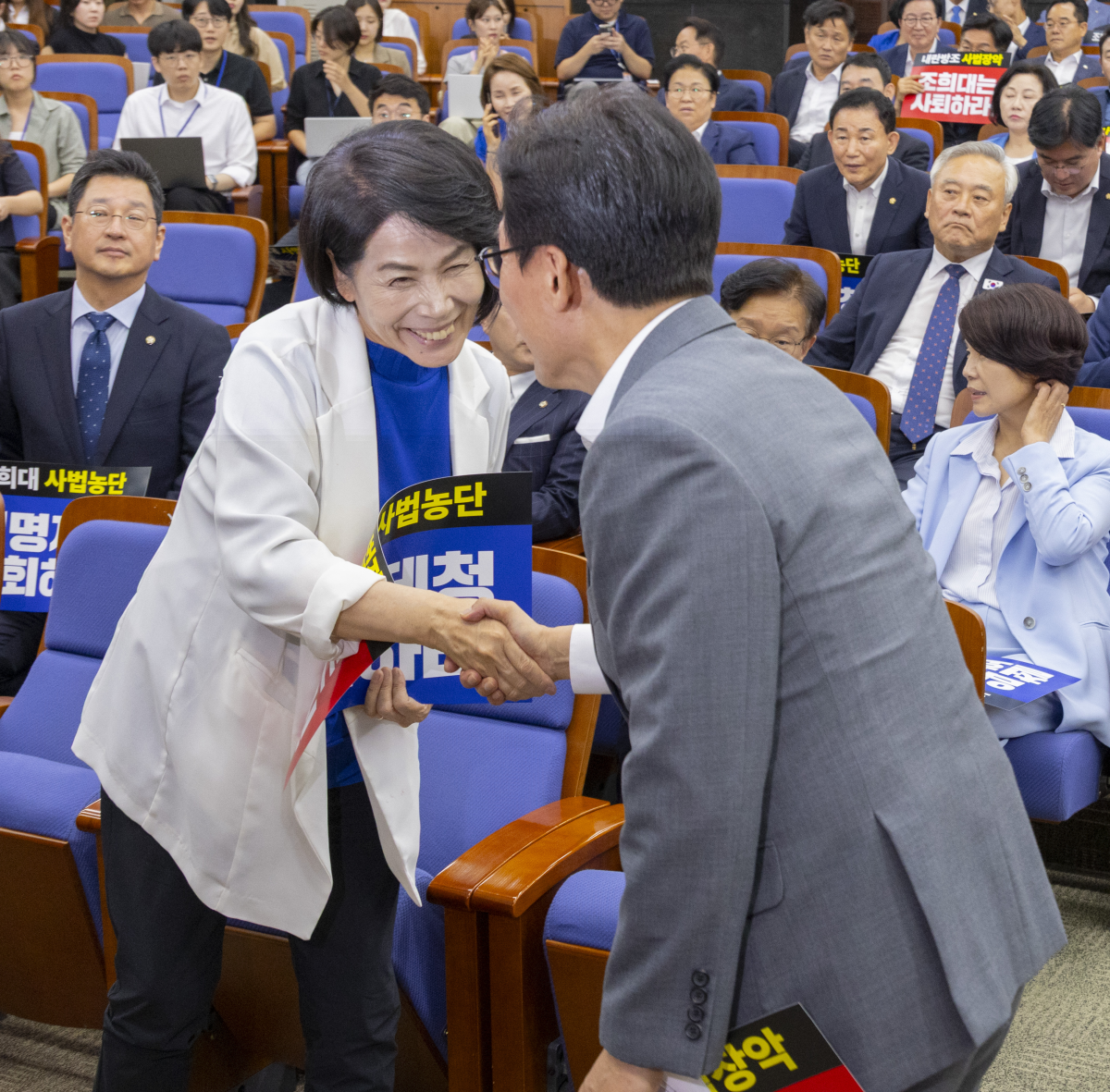 최민희(왼쪽) 더불어민주당 최고위원이 20일 국회에서 전당대회 뒤 처음으로 열린 의원 총회에서 김민석 대표와 악수하고 있다. 2026.8.20 연합뉴스
