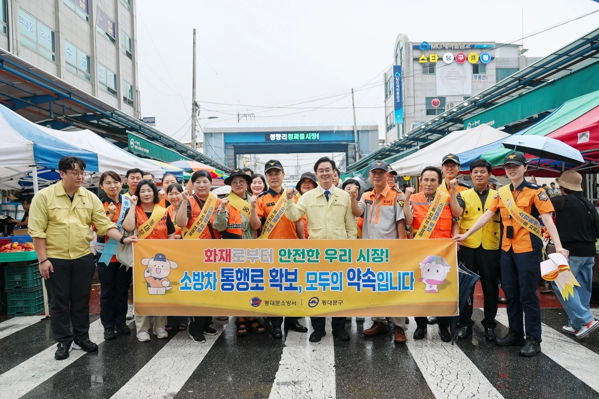 최동민(가운데) 동대문구청장은 동대문소방서, 의용소방대, 시장 상인회 등과 함께 청량리 청과물시장 일대에서 소방통로 확보 당부 홍보 캠페인을 펼친 후 기념 사진을 찍고 있다. 동대문구 제공