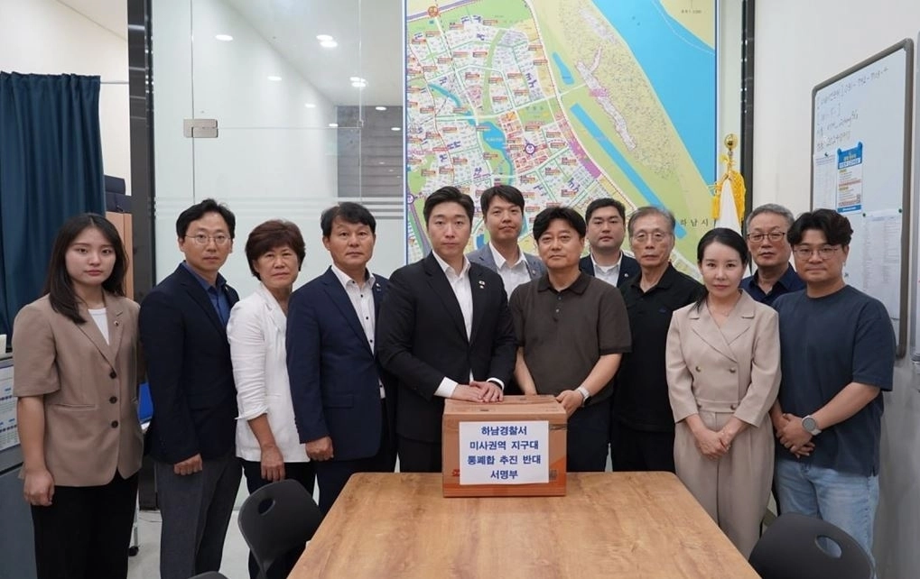 미사 지역 주민들이 지난 18일 더불어민주당 하남시(을) 시·도의원들에게 미사권역 지구대 통폐합 반대 서명부를 전달하고 있다. 하남시의회 제공