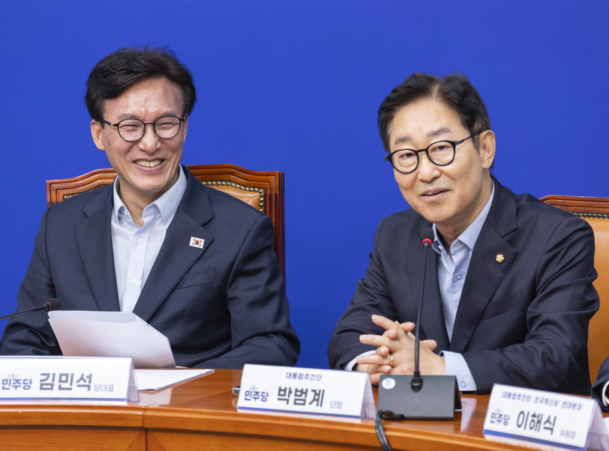 김민석 더불어민주당 대표가 25일 국회에서 열린 대통합 추진단 1차 회의에서 단장인 박범계 의원의 인사말을 들으며 웃고 있다. 연합뉴스
