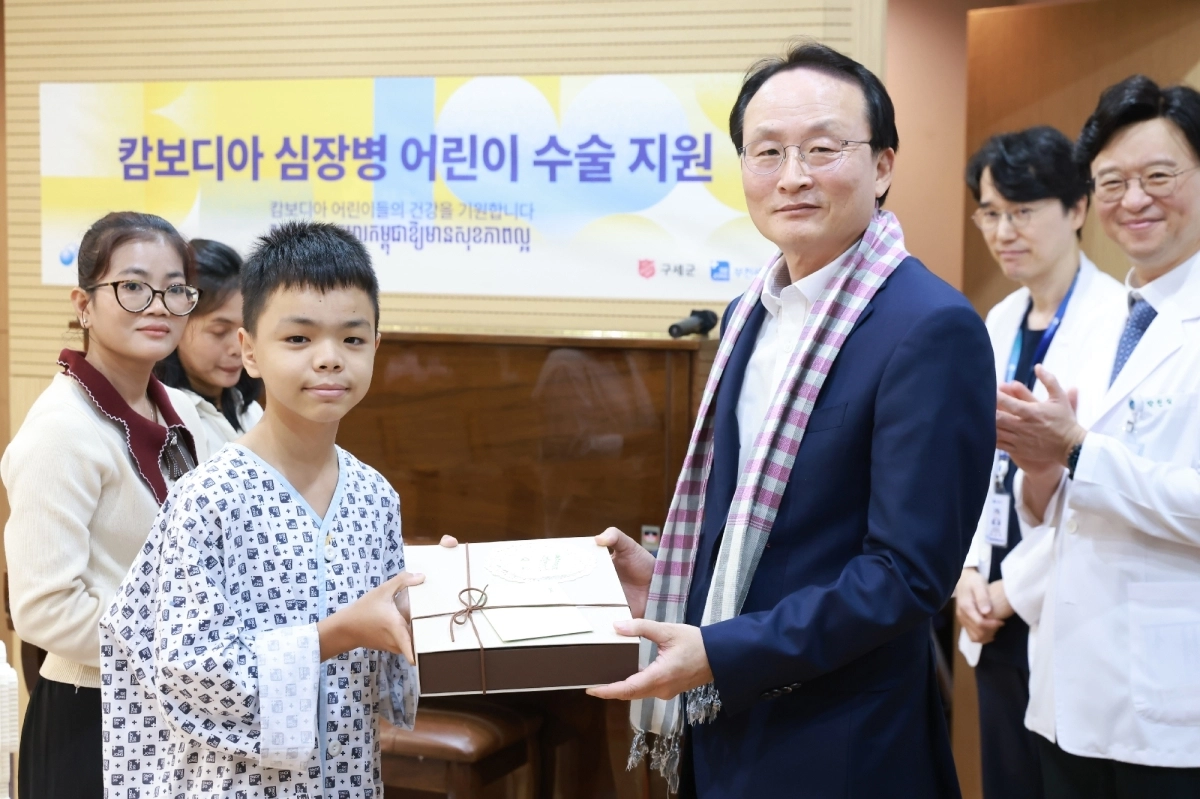 이환주(앞 줄 오른쪽) KB국민은행장이 지난 24일 경기 부천 세종병원에서 열린 ‘캄보디아 심장병 어린이 수술 지원 행사’에서 환아에게 선물을 전달하고 기념사진을 찍고 있다.  KB국민은행
