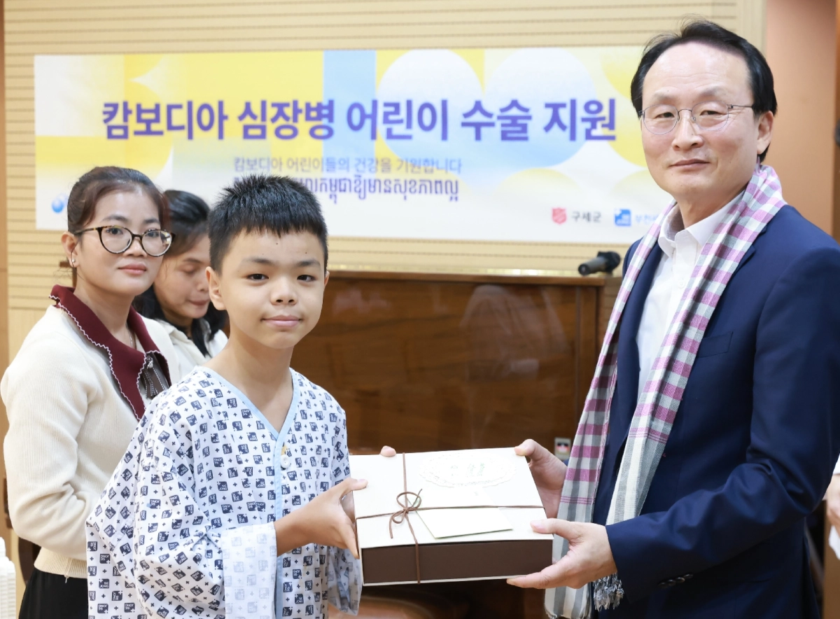 이환주(맨 오른쪽) KB국민은행장이 지난 24일 경기 부천 세종병원에서 열린 ‘캄보디아 심장병 어린이 수술 지원 행사’에서 환아에게 선물을 전달하고 기념사진을 찍고 있다. KB국민은행