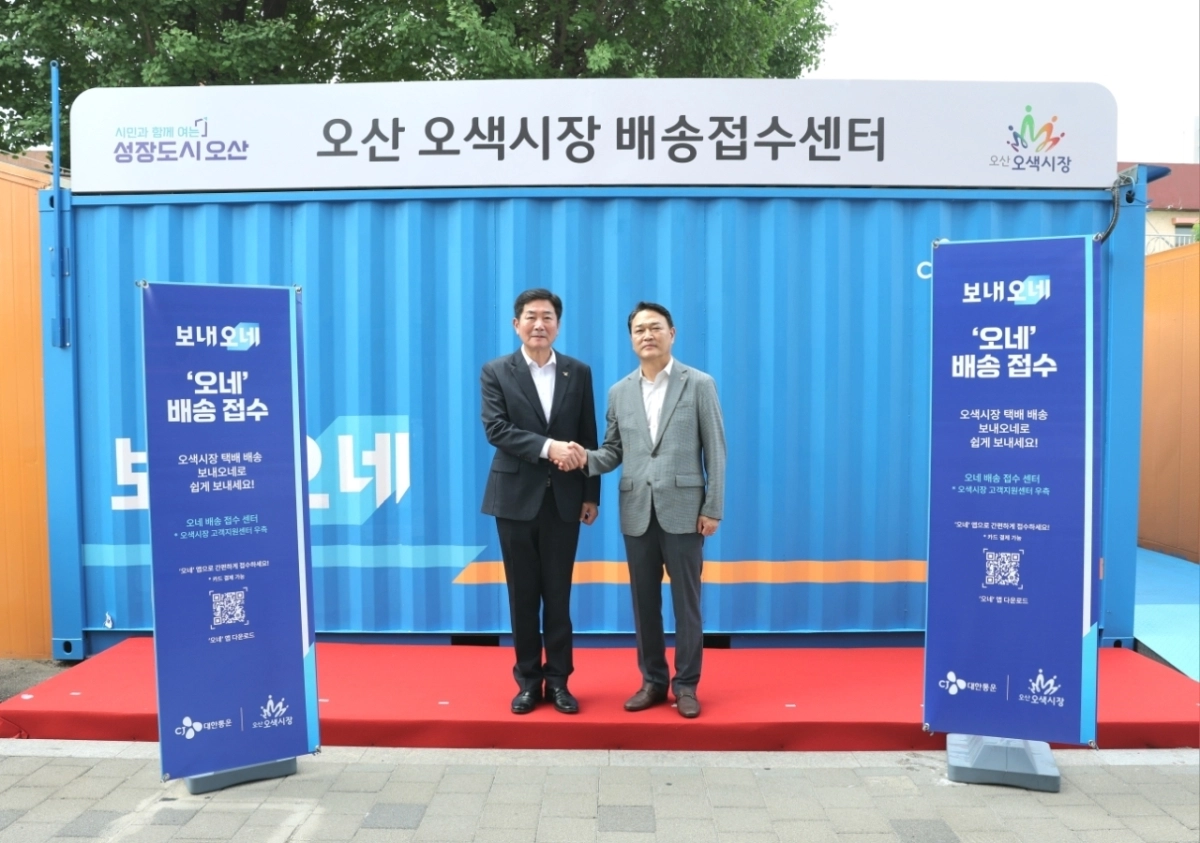 26일 오산오색시장 ‘디지털 배송센터’ 개소식에 참석한 조용호 오산시장(왼쪽)과 윤재승 CJ대한통운 오네(O-NE) 본부장이 기념 촬영을 하고 있다. 오산시 제공