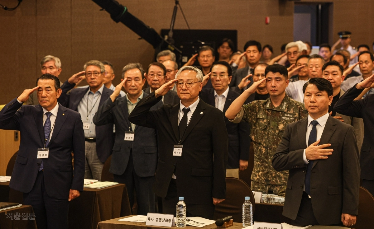 26일 서울 용산구 국방컨벤션에서 열린 국군사관학교 창설 공청회 참석자들이 국민의례를 하고 있다. 앞줄 오른쪽부터 김홍철 국방부 정책실장, 박판준 육군사관학교 총동창회장, 이범림 해군사관학교 총동창회장.  홍윤기 기자