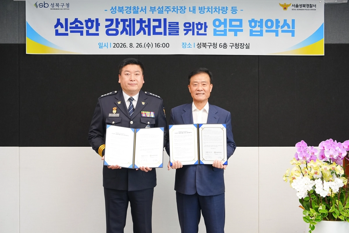 이승로(오른쪽) 성북구청장과 김정완 성북경찰서장이 26일 구청에서 성북경찰서 부설주차장 내 무단 방치 차량 및 장기 주차위반 차량 등의 강제처리를 위한 업무협약을 체결하고 기념 촬영을 하고 있다. 성북구 제공