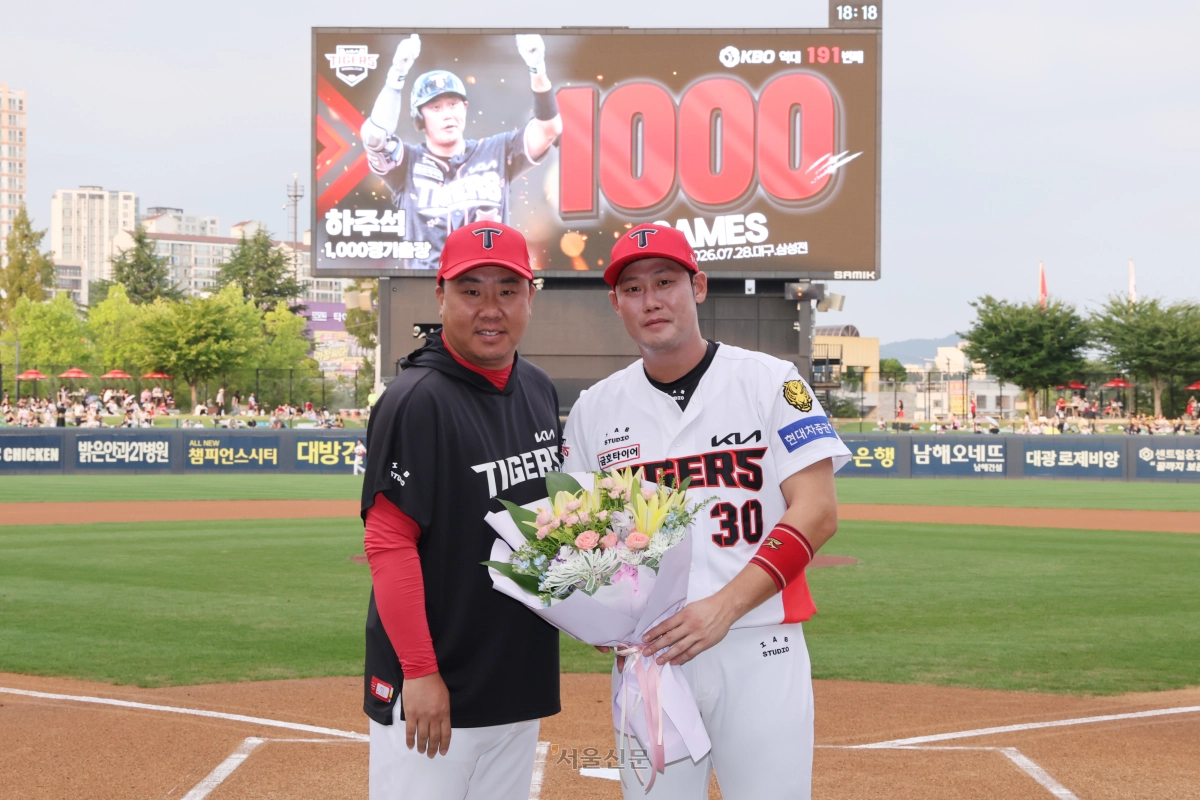 KIA 타이거즈 내야수 하주석(오른쪽)이 26일 광주 기아챔피언스필드에서 이범호 감독과 함께 1000경기 출장 기념 사진을 찍고 있다. 2026.8.26 KIA 타이거즈 제공
