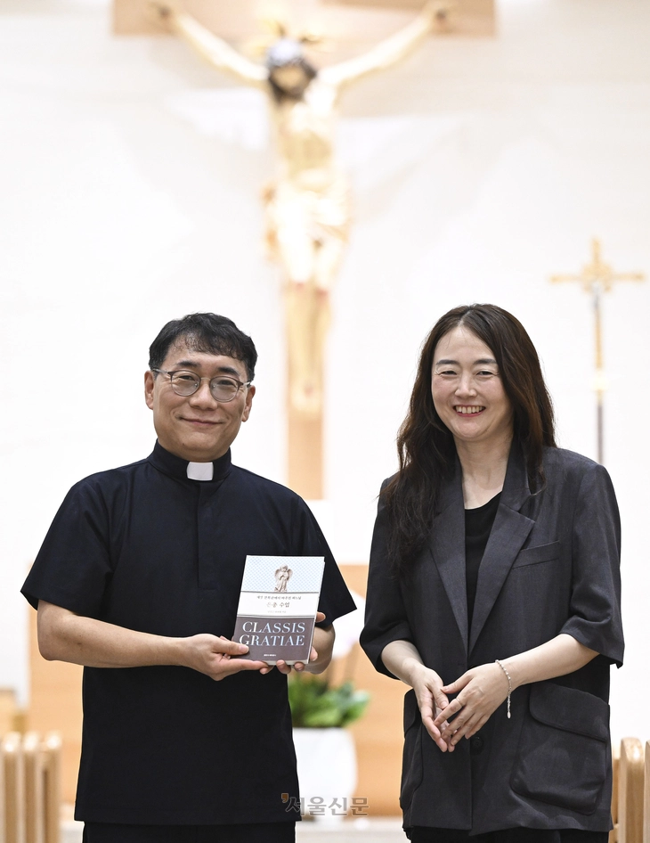 남상근(왼쪽) 라파엘 신부와 소설가 김금희가 지난 24일 서울 공덕동성당 본당에서 책 ‘은총수업’을 들고 있다. ‘은총수업’은 남 신부의 첫 산문집이자 김금희가 운영하는 출판사 페퍼로니의 첫 번째 책이기도 하다. 이지훈 기자