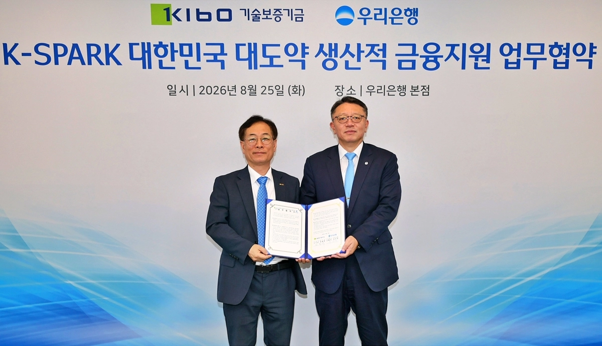 정진완(오른쪽) 우리은행장과 권형택 기술보증기금 이사장이 지난 25일 서울 중구 우리은행 본점에서 생산적 금융 지원을 위한 업무협약(MOU)을 체결한 뒤 기념사진을 찍고 있다. 우리은행 제공