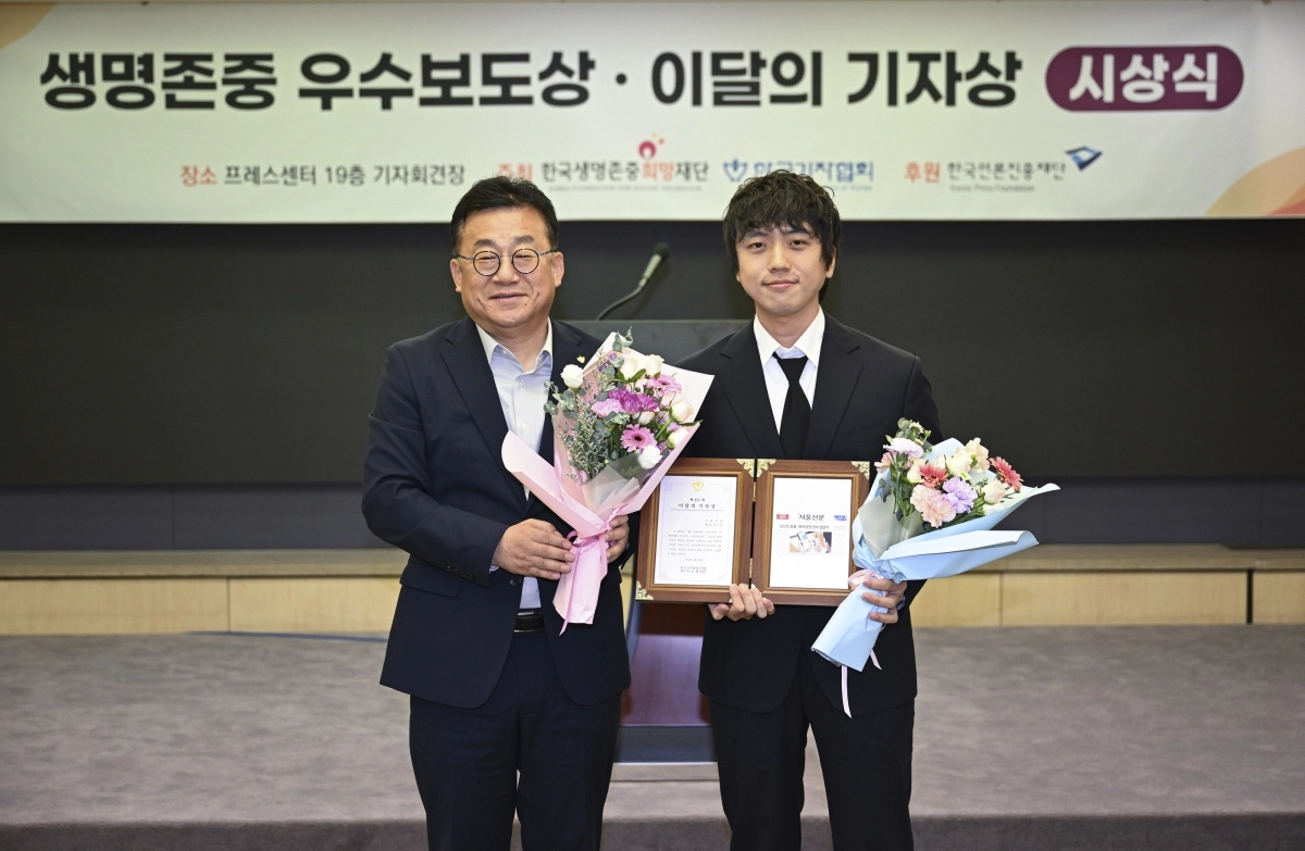 본지 사진부 홍윤기(오른쪽) 기자와 박종현 한국기자협회장이 27일 서울 중구 한국프레스센터에서 열린 이달의 기자상 시상식에서 기념 촬영을 하고 있다. 2026.8.27 이지훈 기자