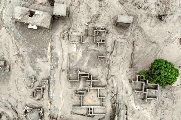 A drone view shows mud covering buildings following a flash flood in Trishuli