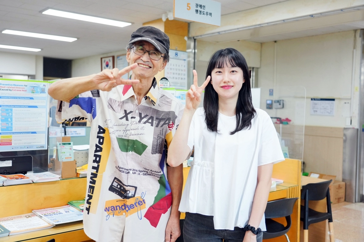 지난 11일 감사 편지를 전하기 위해 서울 성북구 보문동주민센터를 찾은 양찬종(왼쪽)씨와 주하영 주무관이 기념촬영을 하고 있다. 성북구 제공