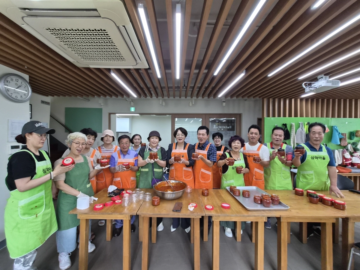 서울 성북구 삼덕마을 주민들이 지난 27일 모여 만든 고추장볶음을 들고 기념 촬영을 하고 있다. 성북구 제공