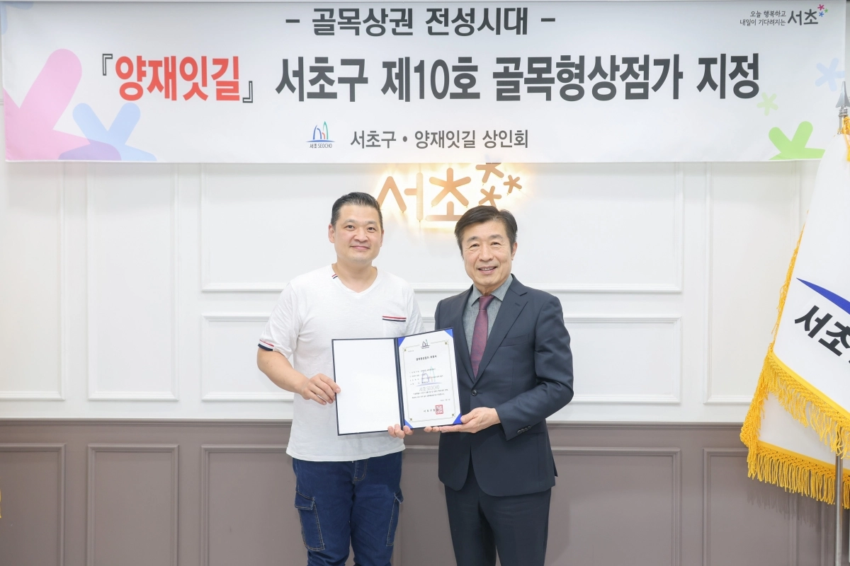 전성수(오른쪽) 서초구청장과 이승범 양재잇길 상인회장이 지난달 31일 구청에서 열린 제10호 골목형상점가 지정식에서 기념 촬영을 하고 있다.  서초구 제공