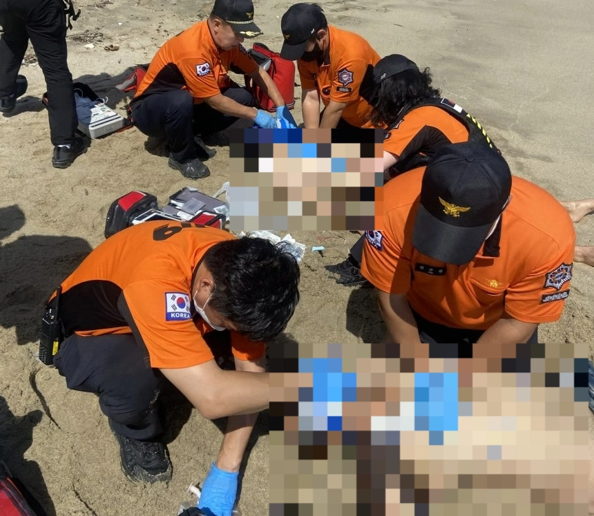5일 소방대원들이 경북 울진군 기성면 망양황금대게공원 앞 해안에서 물에 빠져 심정지 상태로 구조된 수영객들에 심폐소생술을 하고 있다. 두 사람은 끝내 숨졌다(사진 일부 모자이크 처리함). 경북소방본부 제공