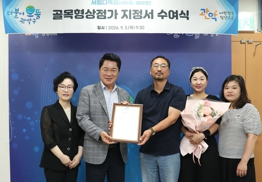 박준희(왼쪽 두번째) 서울 관악구청장이 지난 3일 서림다복길의 골목형상점가 지정서를 전달하고 있다.  관악구 제공