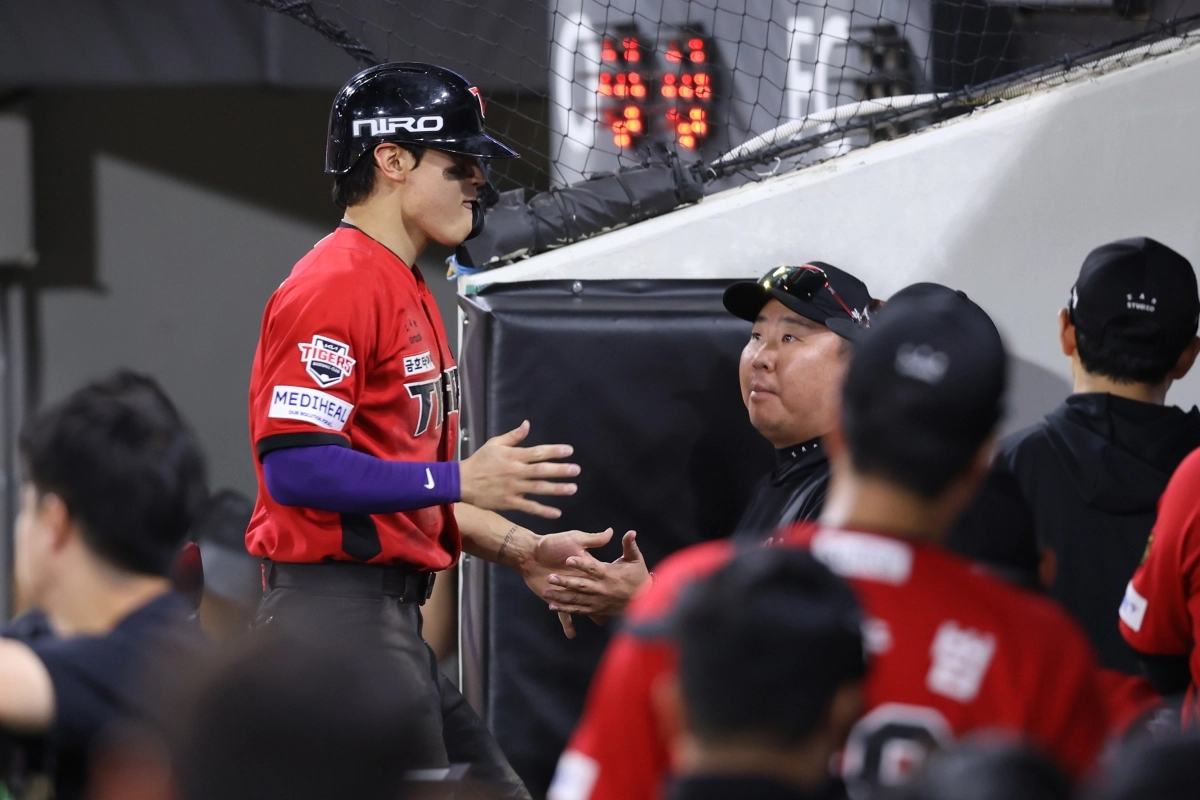 KIA 김도영(왼쪽)이 6일 kt전에서 쐐기득점을 올린 뒤 더그아웃으로 돌아와 이범호 감독과 손을 맞대고 있다.     KIA 타이거즈 제공