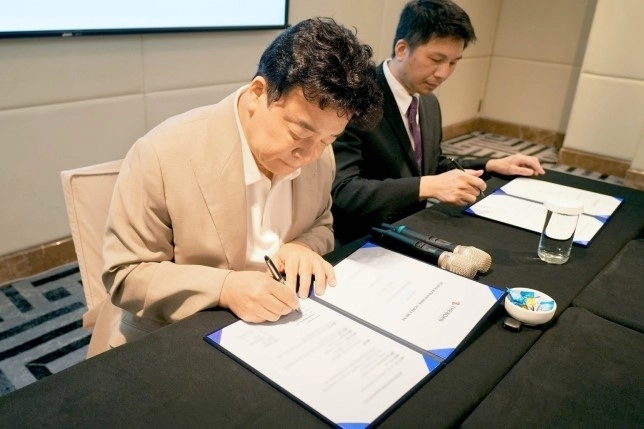 백종원 더본코리아 대표가 대만 현지 파트너사와 빽다방의 대만 진출을 위한 마스터프랜차이즈(MF) 계약서에 서명하고 있다. 더본코리아 제공