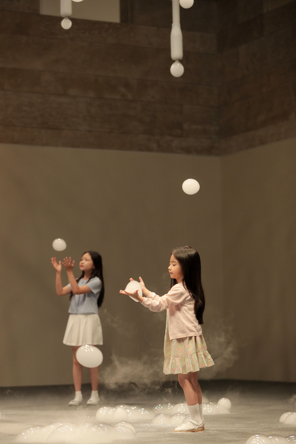 아티스트 듀오 A.A. 무라카미의 작품 ‘뉴 스프링’ 아래서 어린이가 하얀 비눗방울을 만지며 작품을 경험하고 있다. 파라다이스시티 제공