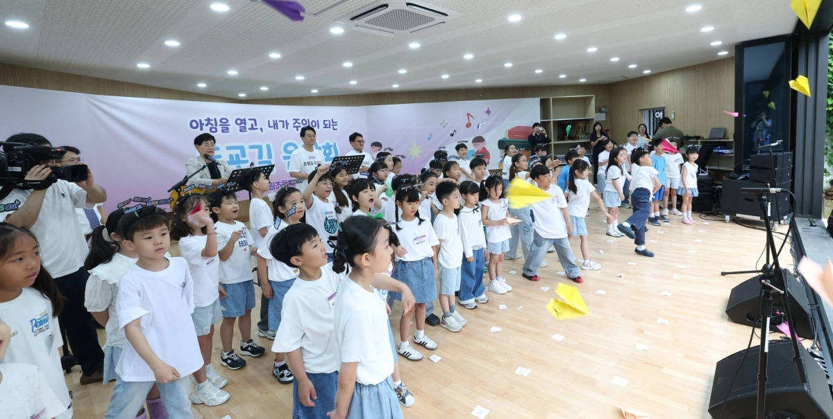 안민석 경기교육감과 가수 윤형주가 지난달 31일 성남 하원초등학교에서 열린 ‘손잡고 RAS 온(ON)!’ 행사의 등굣길 음악회에서 어린이들과 함께 노래하고 있다. 경기교육청 제공