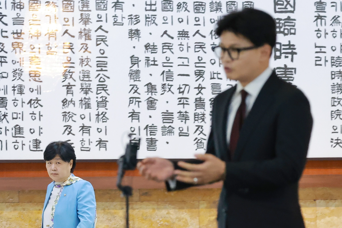 서영교(왼쪽) 국회 법사위원장이 지난 9일 국회 로텐더홀에서 김승원 법무부 장관 후보자와 관련해 취재진 질문에 답하는 한동훈 무소속 의원을 노려 보며 지나가고 있다. 연합뉴스