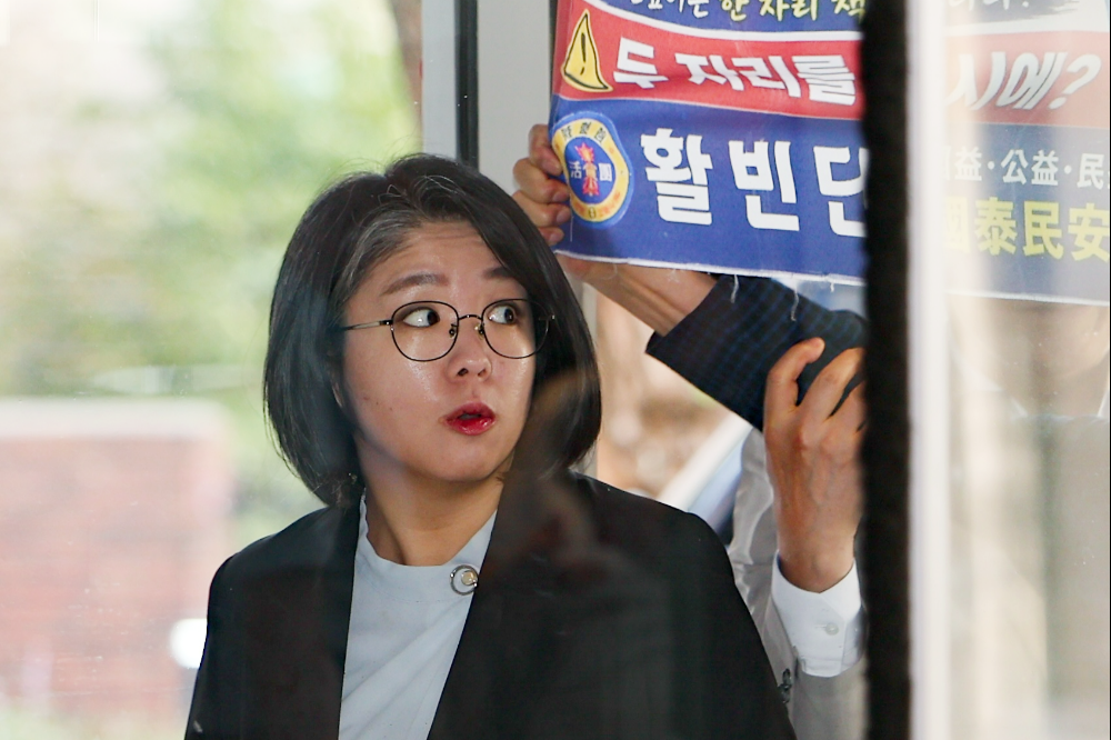 용혜인 성평등가족부 장관 후보자가 11일 오전 서울 서대문구 한국청소년활동진흥원에 마련된 인사청문회 준비 사무실로 출근하던 중 ‘국회의원과 장관 중 택일하라’고 적힌 현수막을 들고 항의하는 시민을 보고 놀라고 있다. 2026.09.11. 뉴시스