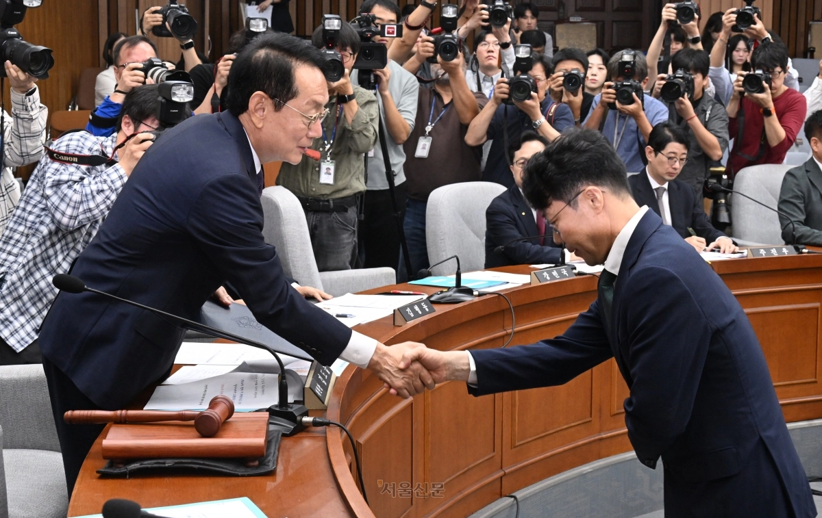 김성수 대법과 후보자가 14일 국회에서 열린 대법관(김성수) 임명 동의에 관한 인사청문특별위원회 청문회에 출석해 선서를 마친 뒤 김도읍 위원장에게 제출한 뒤 악수하고 있다. 안주영 전문기자