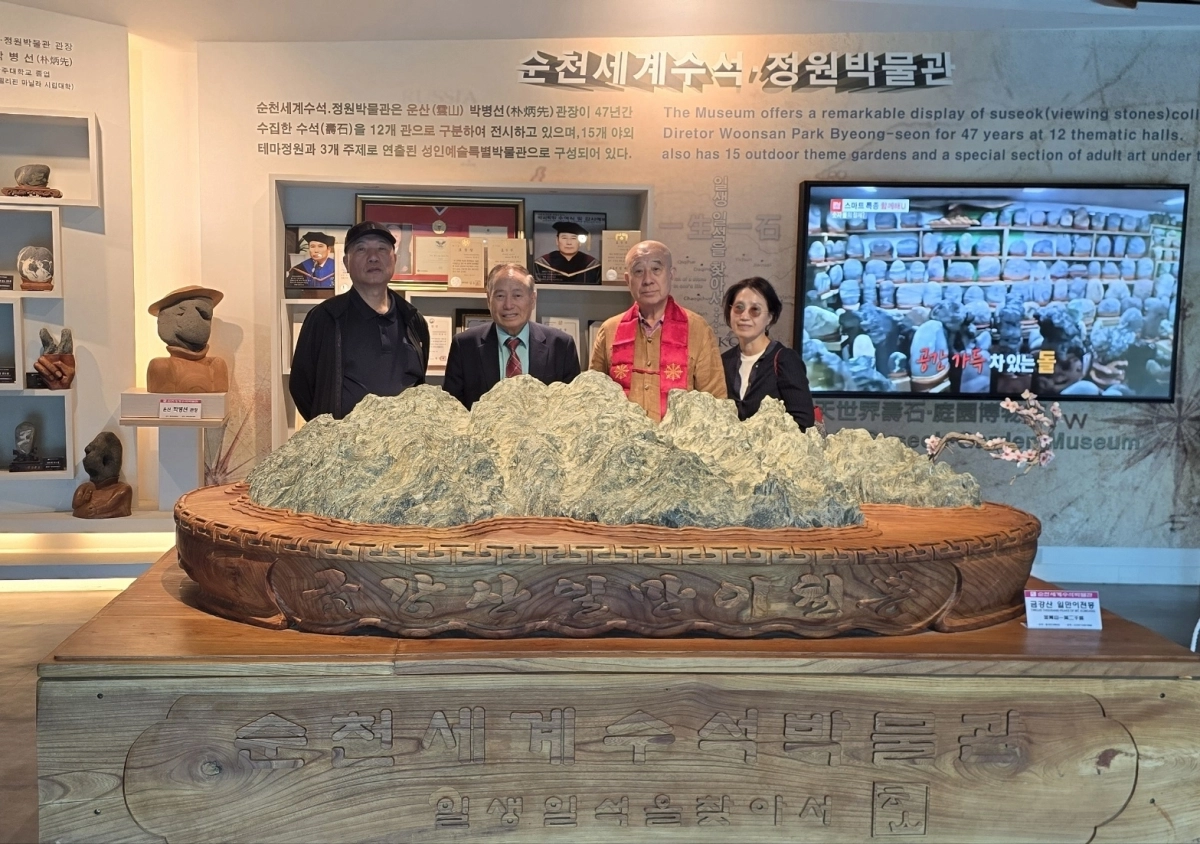 박병선 순천세계수석박물관장과 보검스님 일행이 박물관 1층 현관에 있는 금강산 일만이천봉 수석 앞에서 기념사진을 찍고 있다.