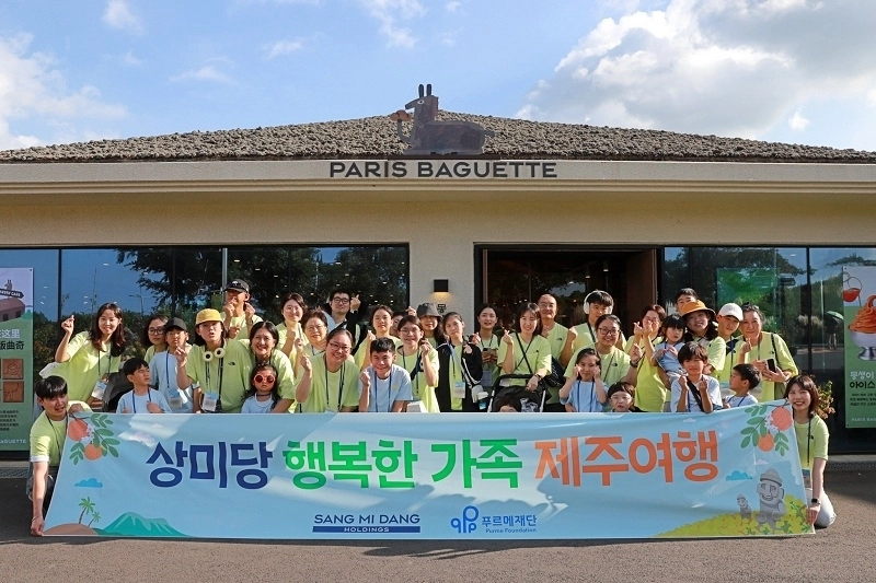 제주도에서 진행된 …상미당 행복한 가족여행‘에 참가한 장애어린이 가족과 상미당홀딩스 임직원 봉사자들이 파리바게뜨 동화마을점 앞에서 기념 촬영을 하고 있다.