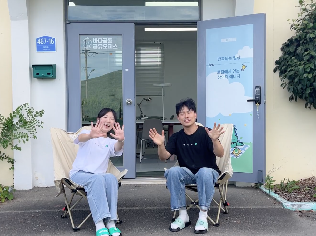 경남 고성 청년기업 바다공룡의 최보연(왼쪽) 대표와 강명훈 팀원이 대가면의 옛 예비군 훈련소를 리모델링한 공유오피스 앞에서 손을 흔들고 있다.  바다공룡 제공