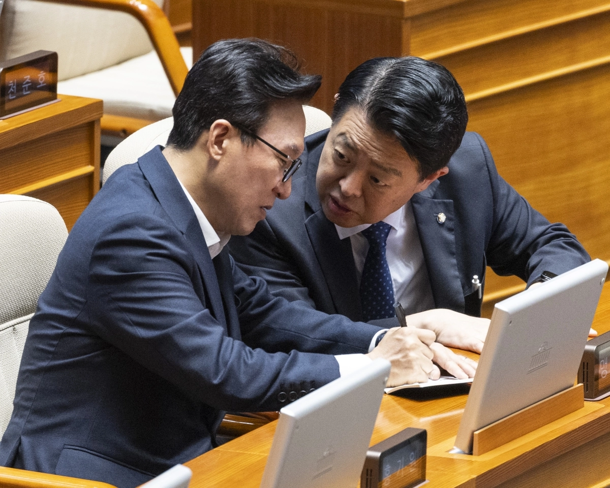 더불어민주당 김민석 대표(왼쪽)가 11일 국회에서 열린 정기국회 제7차 본회의 경제 분야 대정부질문에 참석해 김영호 의원과 대화하다 수첩에 내용을 적고 있다.  2026.9.11 연합뉴스