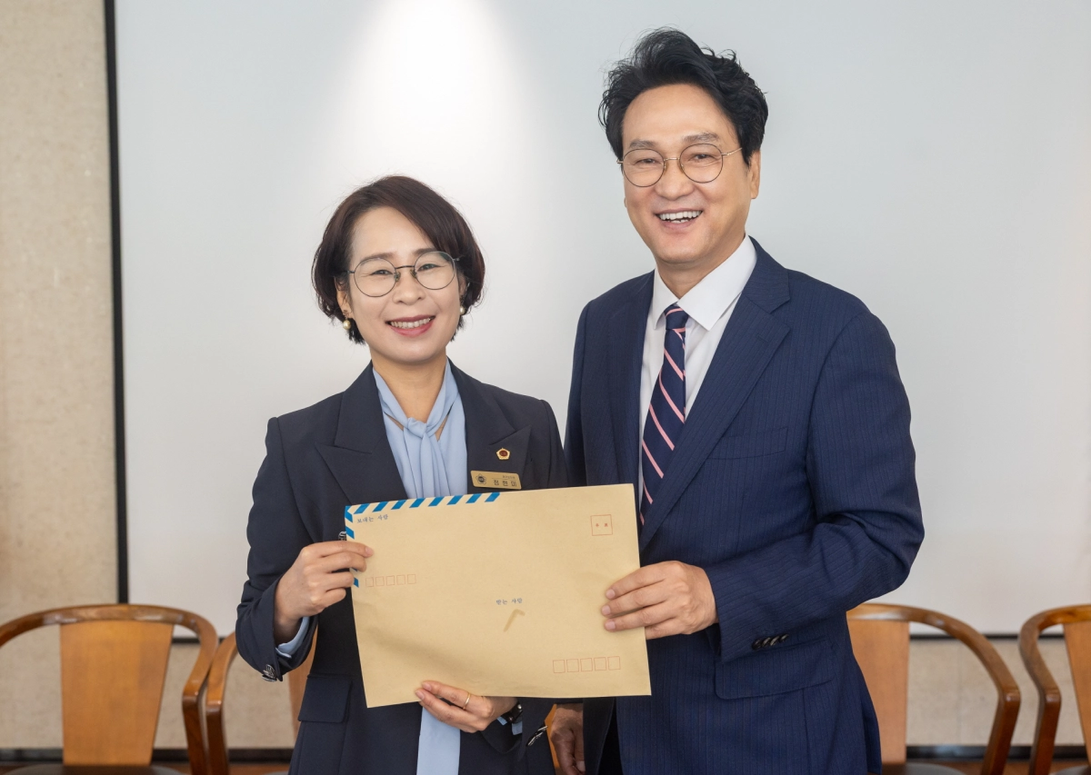 ▲정현미 의원이 17일 조찬 간담회에서 안민석 경기도교육감에게 남양주 덕소초등학교 교육 현안 건의서를 전달하고 있다. (사진=경기도의회)