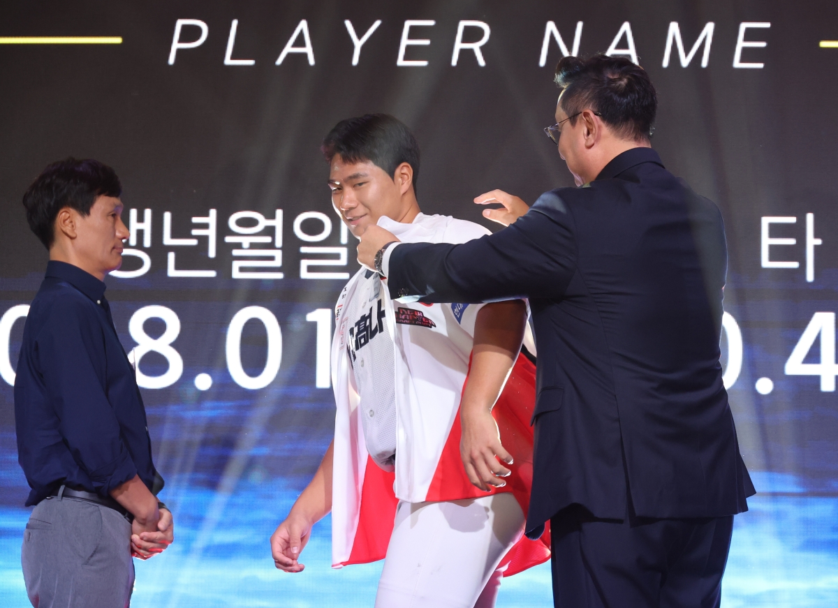 21일 서울 롯데호텔 월드에서 열린 2027 KBO 신인 드래프트에서 1라운드 3순위로 기아 타이거즈 지명을 받은 경남고 이호민이 유니폼을 받아 입고 있다.     연합뉴스