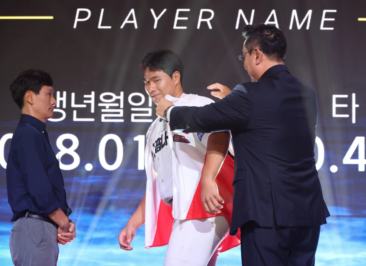 21일 서울 롯데호텔 월드에서 열린 2027 KBO 신인 드래프트에서 1라운드 3순위로 기아 타이거즈 지명을 받은 경남고 이호민이 유니폼을 받아 입고 있다.     연합뉴스