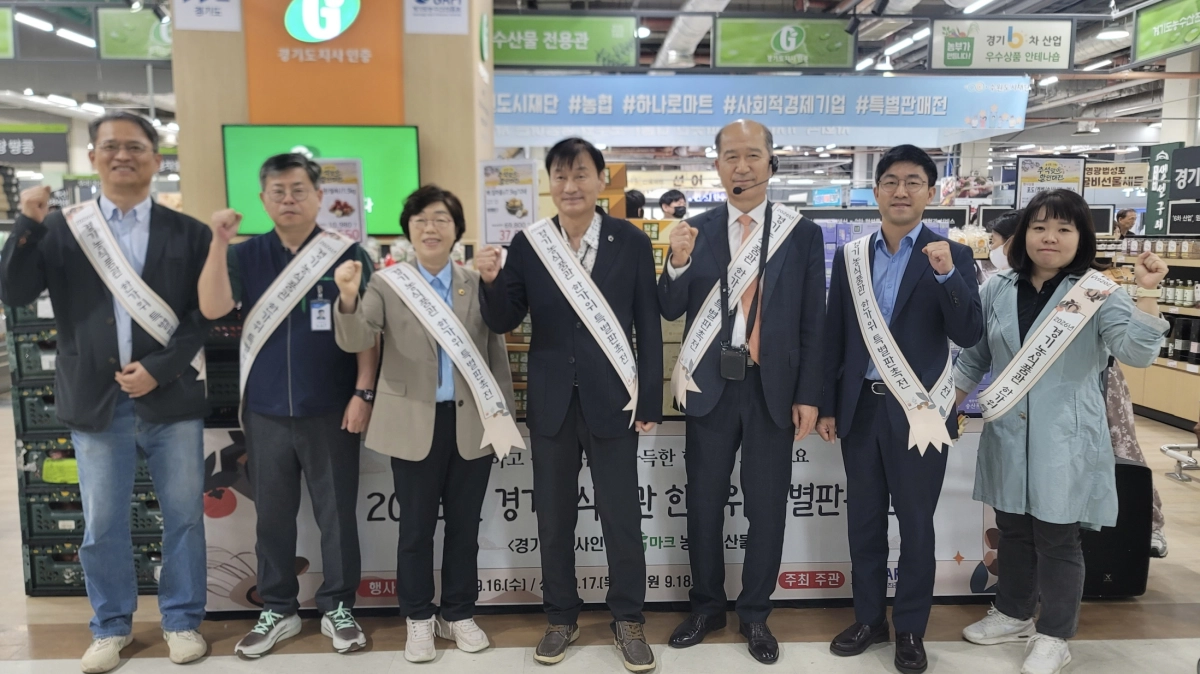 ▲서광범 농정해양위원장과 박옥분 의원이 18일 수원 하나로마트 경기농식품관에서 열린 한가위 특별판매전에서 관계자들과 함께 경기 농산물 소비 촉진 어깨띠를 두르고 기념 촬영을 하고 있다. (사진=경기도의회)