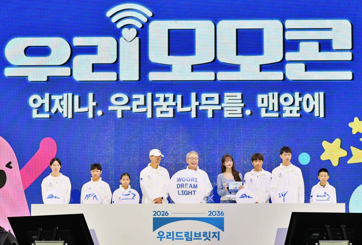 임종룡(왼쪽 다섯 번째) 우리금융그룹 회장과 가수 션(왼쪽 네 번째), 장원영(왼쪽 여섯 번재)이 지난 19일 경기 과천 서울랜드에서 열린 ‘2026 우리 모모콘’에서 스포츠 사회공헌 사업을 선포하고 있다. 우리금융그룹 제공
