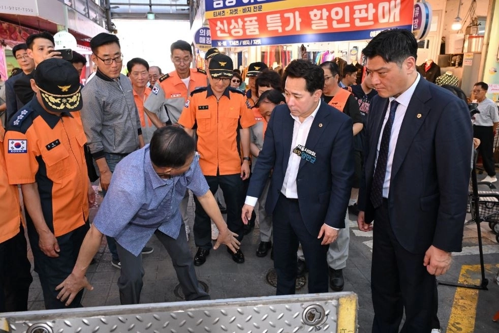 추석을 앞둔 지난 22일 전통시장을 찾은 임만균 서울시의회 의장이 지하소화장치함을 점검하고 있다. 서울시의회 제공