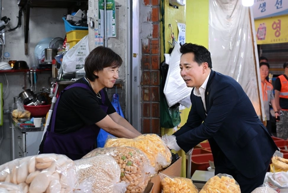 추석을 앞둔 지난 22일 전통시장을 찾은 임만균 서울시의회 의장이 소상공인과 인사를 나누고 있다. 서울시의회 제공