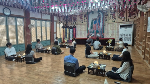 지난 19일 전남광주 선암사의 만세루에서 진행된 순천시 기획 소개팅 프로그램 ‘시절인연’에 참여한 청춘 남녀들이 인연에 대한 화담 스님의 설법을 들으며 차담을 나누고 있다. 순천시 제공