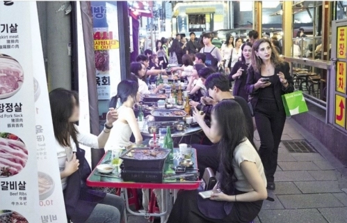 지난 18일 서울 종로구 종로3가에 펼쳐진 야장(야간 장사) 옆을 외국인 관광객들이 지나가고 있다. 종로구 제공