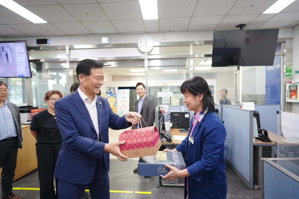 이승로(왼쪽) 성북구청장이 지난 25일 구청 종합 상황실에서 비상근무를 하는 직원에게 선물을 건네며 웃고 있다. 성북구 제공