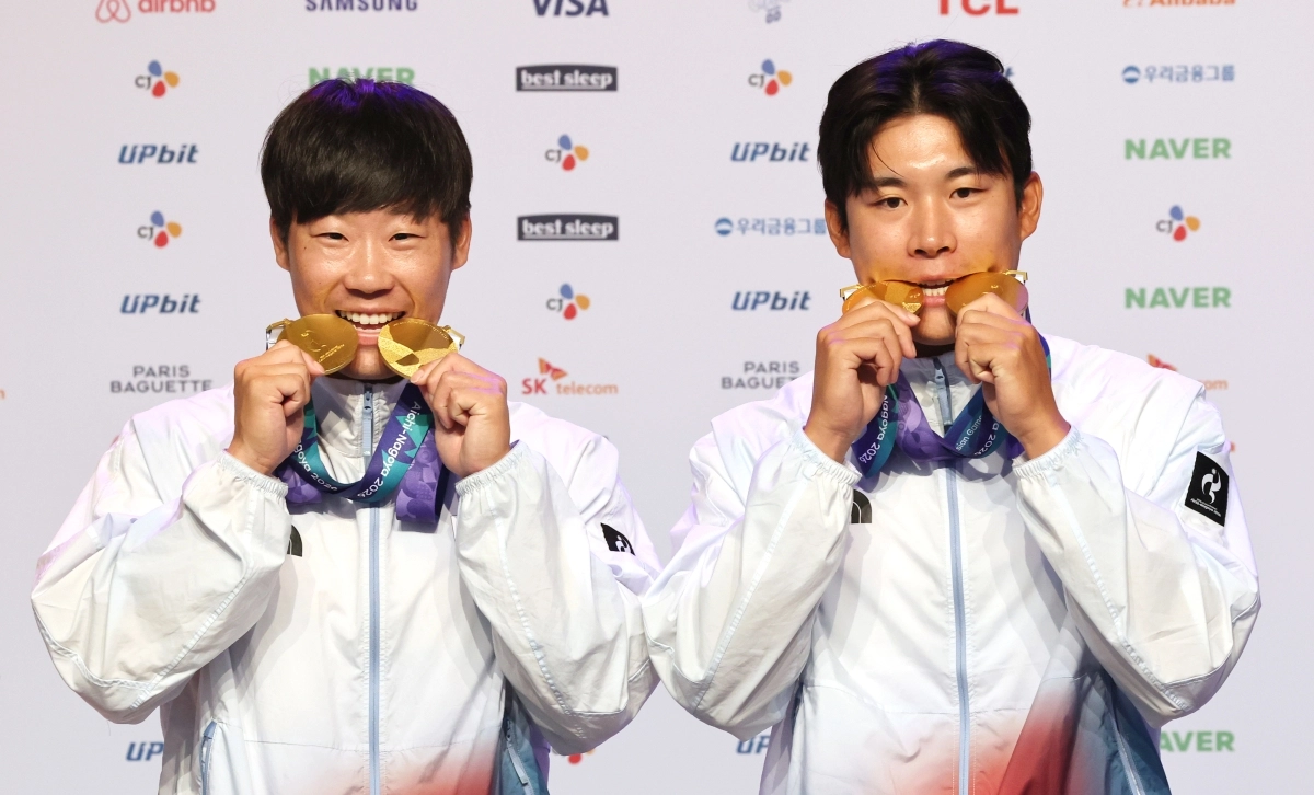 카누 국가대표 조광희(왼쪽)과 김효빈 26일 일본 나고야 코리아하우스에서 열린 메달리스트 기자회견에서 금메달을 깨물며 기념사진을 찍고 있다. 2026.9.26 나고야 연합뉴스