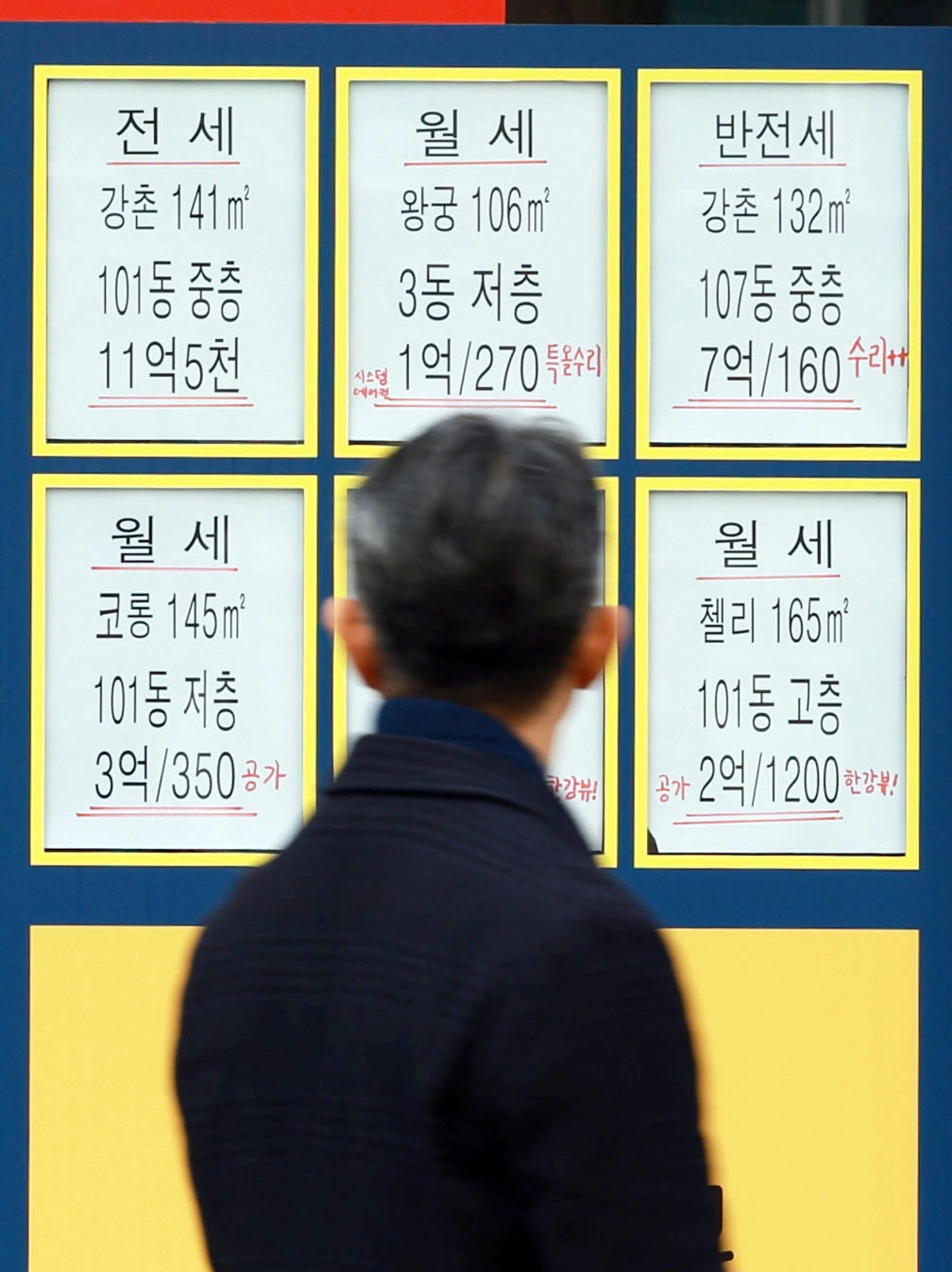 한 시민이 지난해 12월 28일 서울 시내 한 부동산 중개업소 앞에 붙은 전월세 매물을 지켜보고 있다. 연합뉴스