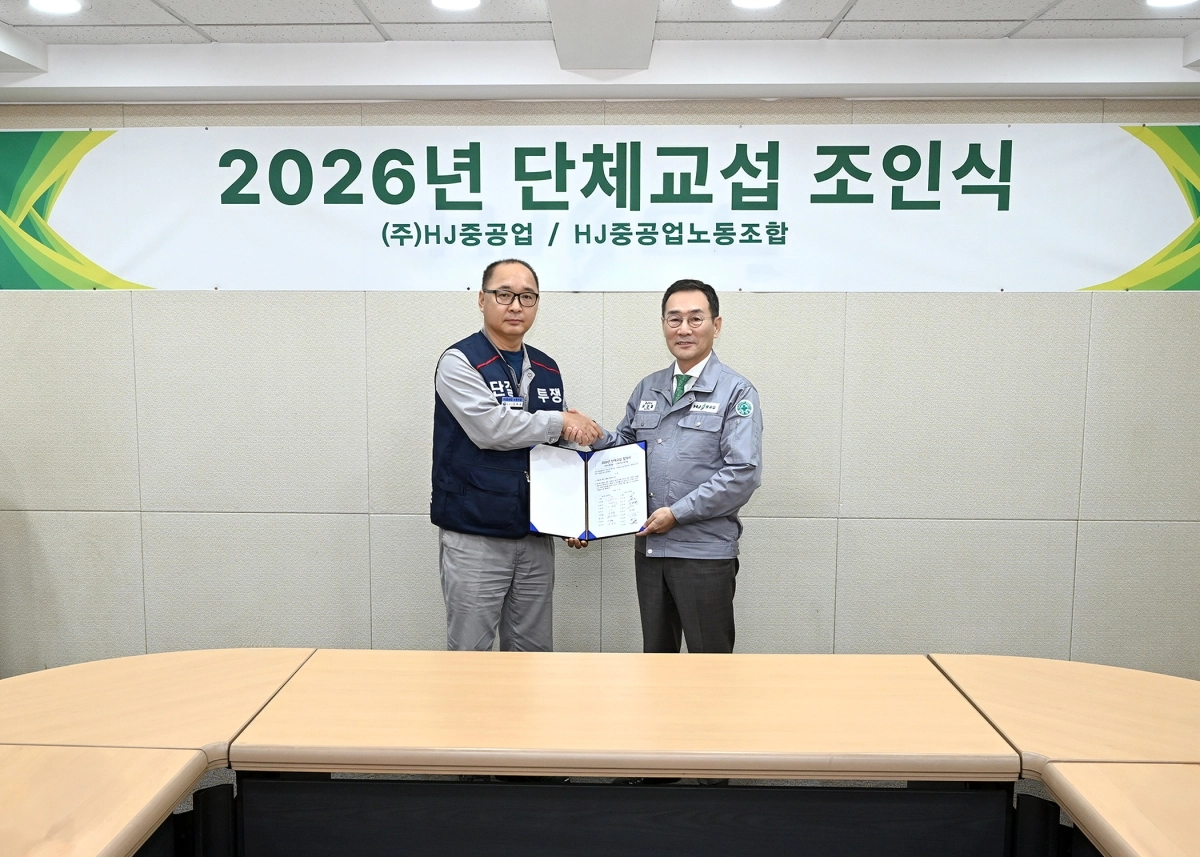 유상철 HJ중공업 대표이사와 김하동 HJ중공업노동조합 위원장이 28일 ‘2026 임금·단체협약 조인식’을 가진 후 기념촬영하고 있다. HJ중공업 제공