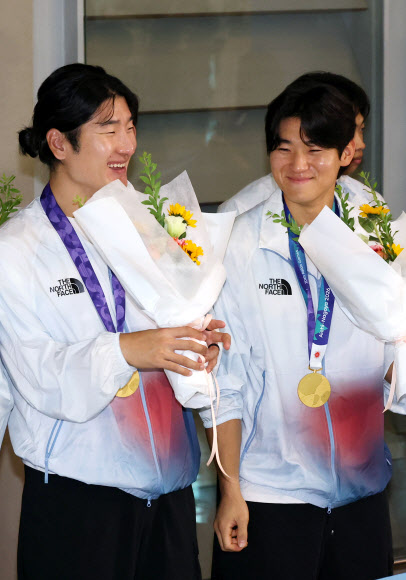 2026 아이치·나고야 아시안게임에서 우승을 차지한 한국 야구 대표팀 곽빈(왼쪽)과 김도영이 28일 인천국제공항을 통해 귀국, 꽃다발을 받고 활짝 웃고 있다. 2026.9.28 연합뉴스