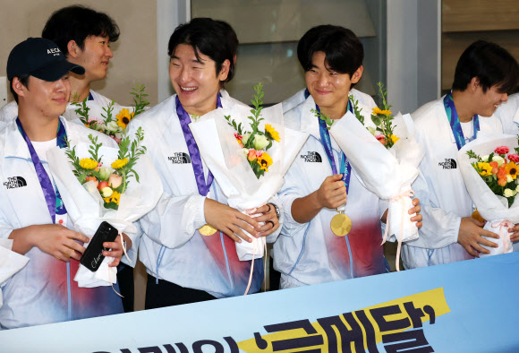 2026 아이치·나고야 아시안게임에서 우승을 차지한 한국 야구 대표팀 노시환(앞줄 왼쪽부터)과 곽빈, 김도영 등 선수들이 28일 인천국제공항을 통해 귀국, 꽃다발을 받고 활짝 웃고 있다. 2026.9.28 연합뉴스