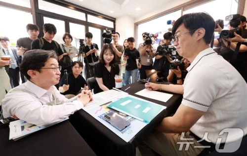 이억원 금융위원장이 1차 ‘청년미래적금’ 가입 신청이 시작된 지난 6월 서울 성동구 신한빌딩에서 상담받는 청년들과 대화를 나누고 있다. 2026.6.22 뉴스1