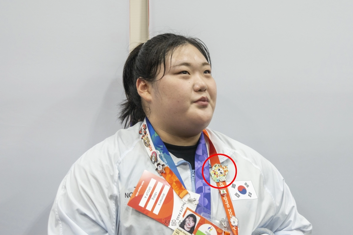 역도 국가대표 박혜정이 29일 일본 아이치현 나고야 중소기업진흥회관에서 열린 2026 아이치·나고야 아시안게임 역도 여자 86㎏ 이상급 경기를 마치고 취재진과 인터뷰하고 있다. 빨간 원 안의 배지가 중국의 리원원에게 받은 배지다. 2026.9.29 나고야 류재민 기자