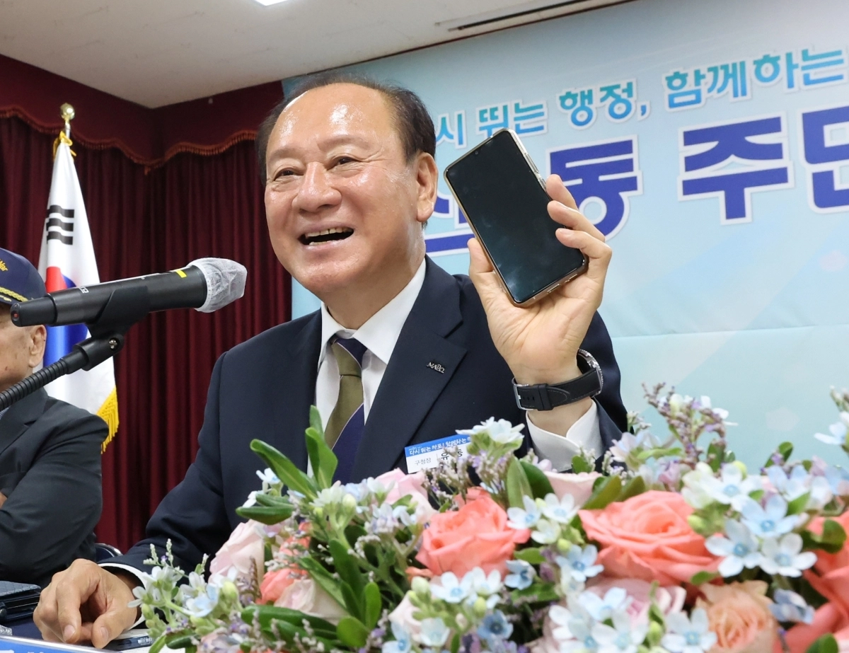 유동균 서울 마포구청장이 지난 7월 14일 신수동에서 열린 주민과의 대화에서 ‘바로바로 소통폰’을 들어 보이며 “언제든 연락을 달라”고 말하고 있다. 마포구 제공