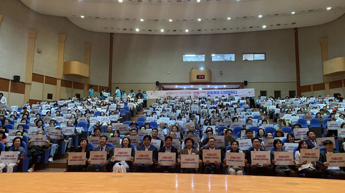 ▲‘제7회 경기도 선배시민대회’에 참석한 도의회 의원 및 도 관계자, 도내 선배시민들이 피켓을 들고 단체 기념촬영을 진행하고 있다. (사진=경기도의회)